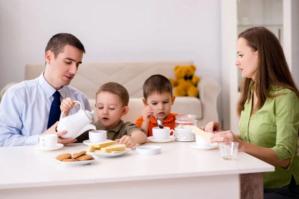 Família feliz tomando café da manhã juntos em casa — Fotografia de Stock