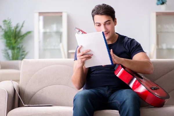 Joven practicando la guitarra en casa — Foto de Stock