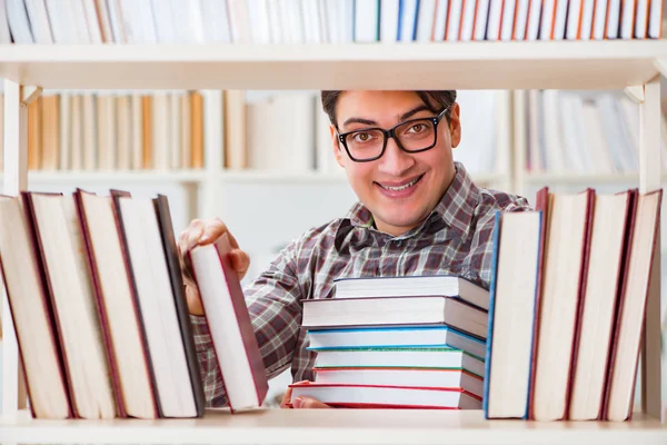 Młody student szuka książek w bibliotece uczelni — Zdjęcie stockowe