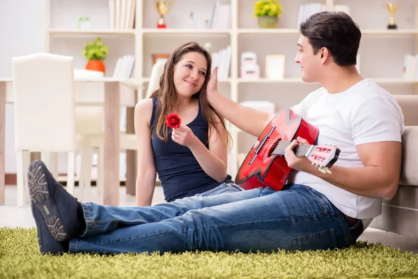 Romantisches Paar spielt Gitarre auf dem Boden — Stockfoto