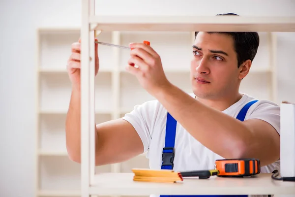 Trabajador reparando montaje estantería — Foto de Stock