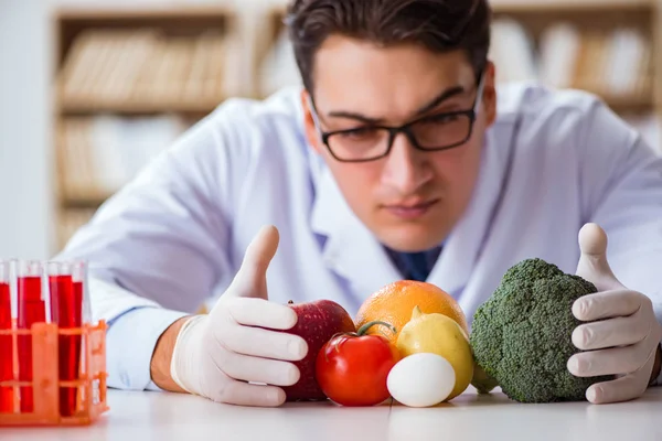 Чоловік лікар перевіряє фрукти та овочі — стокове фото