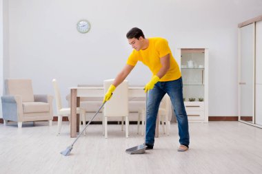 Evi temizleyen adam karısına yardım ediyor.