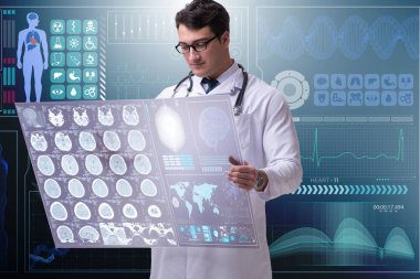 Erkek doktor beyin taraması sonuçlarını inceliyor.