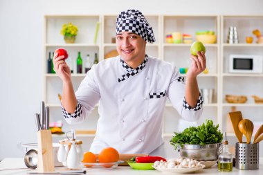 Genç aşçı mutfakta çalışıyor.