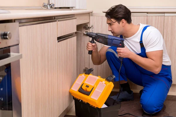 Joven reparador trabajando en la cocina — Foto de Stock