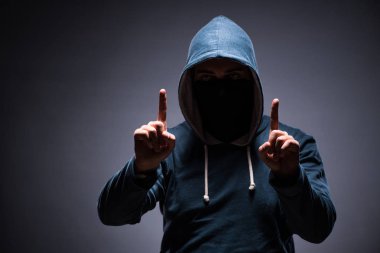 Karanlık odada kaputu giyen adam