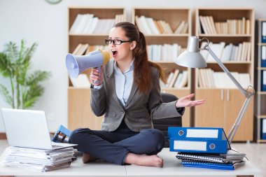 Ofisinde hoparlörü olan iş kadını.
