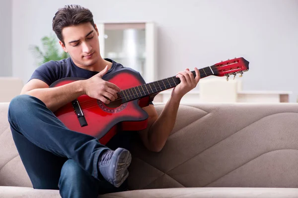 Joven practicando la guitarra en casa — Foto de Stock