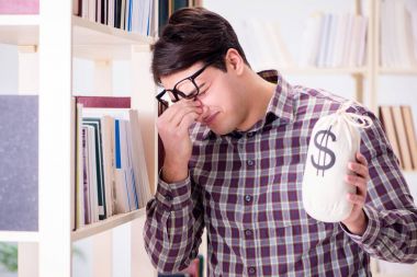 Pahalı ders kitapları konsepti içinde genç bir öğrenci