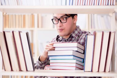 Üniversite kütüphanesinde kitap arayan genç bir öğrenci.