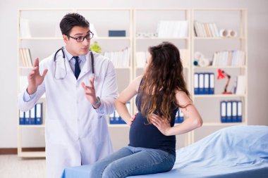 Doktor hamile kadını muayene ediyor.