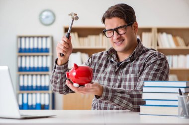 Ders kitabı almak için kumbarayı kıran genç bir öğrenci.