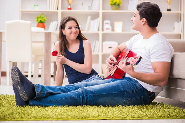 Par romântico tocando guitarra no chão — Fotografia de Stock