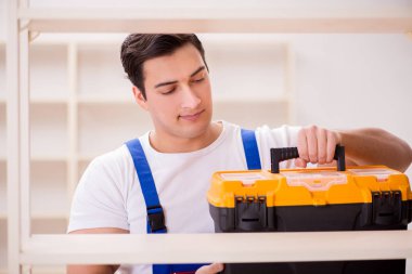 İşçi adam montaj kitaplığını tamir ediyor