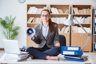 İş kadını ofiste meditasyon yapıyor.