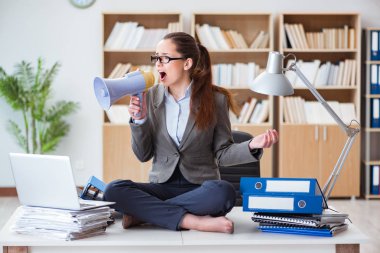 Ofisinde hoparlörü olan iş kadını.