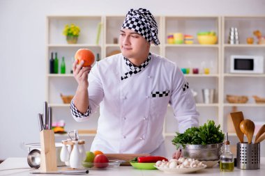 Genç aşçı mutfakta çalışıyor.