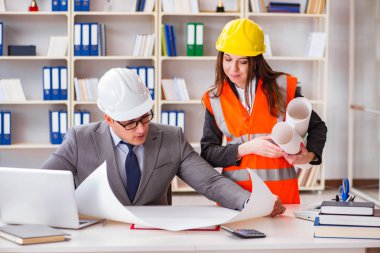 İnşaat ustabaşı çizimleri gözden geçiriyor