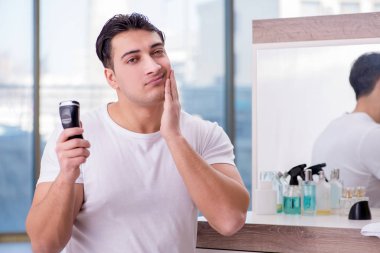 Genç yakışıklı adam sabahları tıraş oluyor.