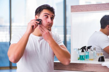 Genç yakışıklı adam sabahları tıraş oluyor.