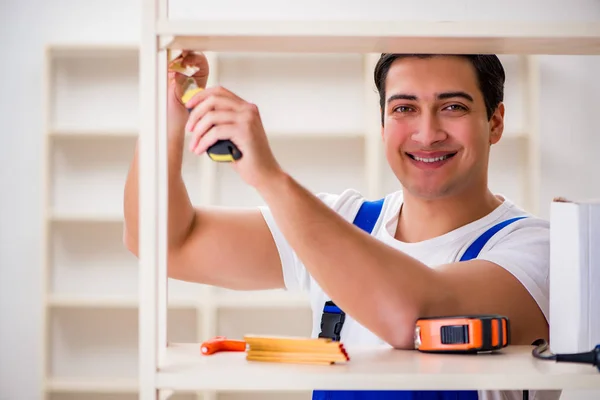 Arbeiter repariert Bücherregal — Stockfoto