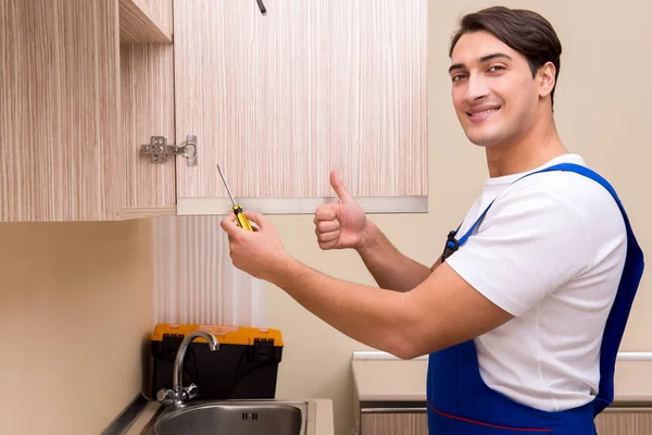 Young man assembling kitchen furniture — Stock Photo, Image