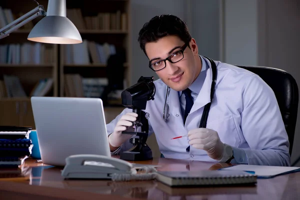 Junger Arzt arbeitet spät im Büro — Stockfoto