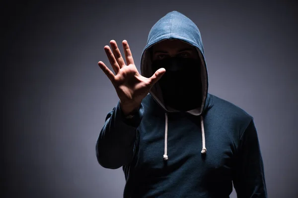 Man wearing hood in dark room — Stock Photo, Image