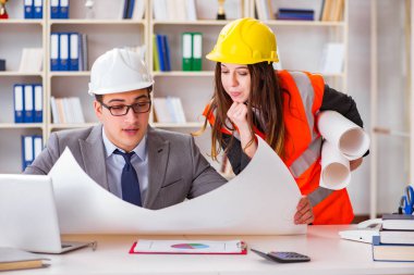 İnşaat ustabaşı çizimleri gözden geçiriyor