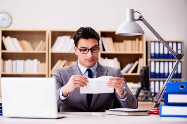 İşadamı mektup zarfını ofisinde alıyor.