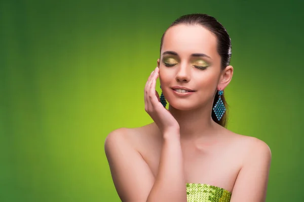 Jovem mulher no conceito de beleza no fundo verde — Fotografia de Stock