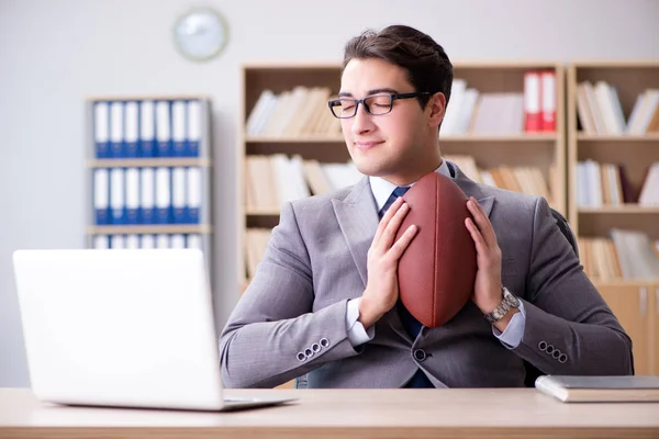 Empresário com futebol americano no escritório — Fotografia de Stock