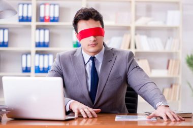 Ofiste masasında oturan gözü bağlı iş adamı.