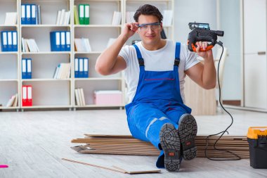 Zemin kaplamalarında çalışan genç bir işçi.