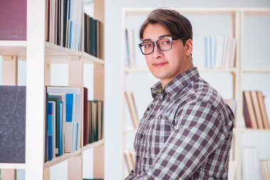 Üniversite kütüphanesinde kitap arayan genç bir öğrenci.