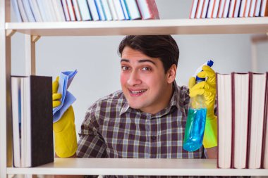 Kitaplıktaki tozları temizleyen adam