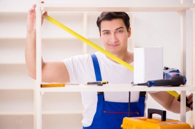 İşçi adam montaj kitaplığını tamir ediyor