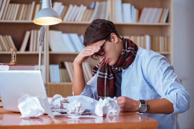 Genç kitap yazarı kütüphanede yazıyor.