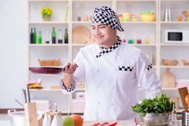 Genç aşçı mutfakta çalışıyor.