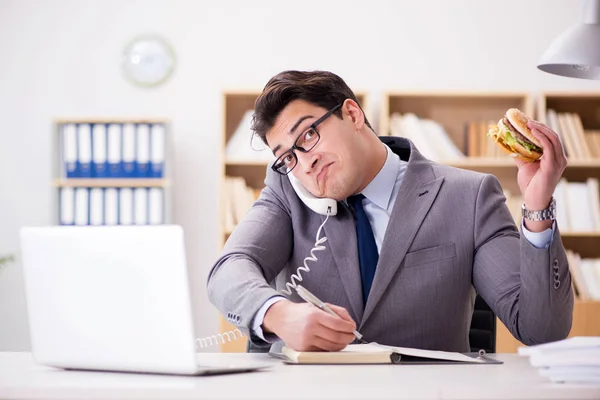 Hungry funny businessman eating junk food sandwich — Stock Photo, Image