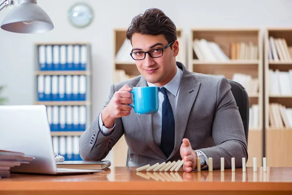 Empresário com dominós no escritório — Fotografia de Stock