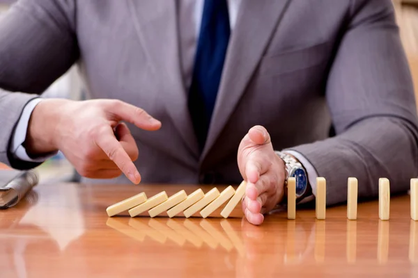 Affärsman med domino på kontoret — Stockfoto