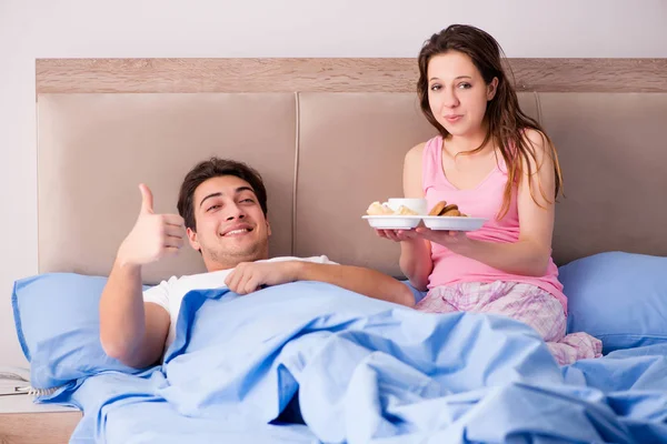 Familia feliz desayunando en la cama — Foto de Stock