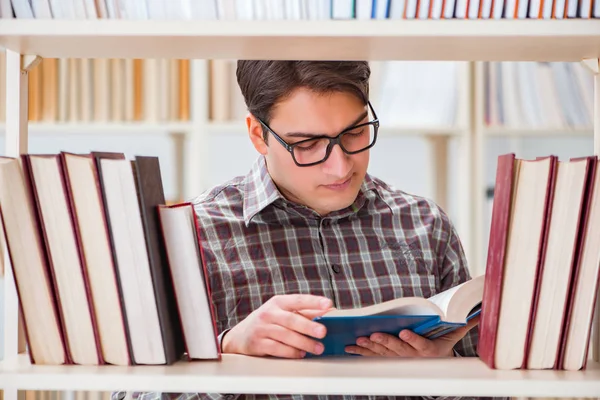 Young student looking for books in college library