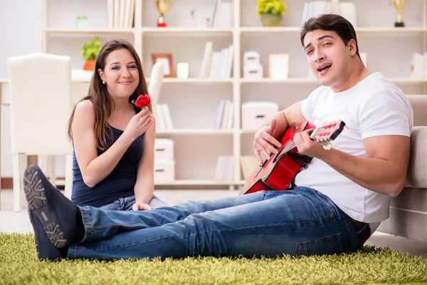 Coppia romantica che suona la chitarra sul pavimento — Foto Stock