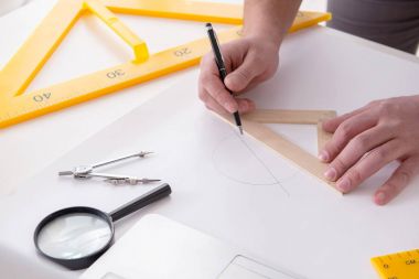 Erkek mühendis çizimler ve planlar üzerinde çalışıyor.