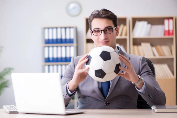 Empresário com bola de futebol no escritório — Fotografia de Stock