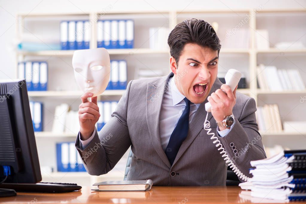 Businessman with mask in office hypocrisy concept