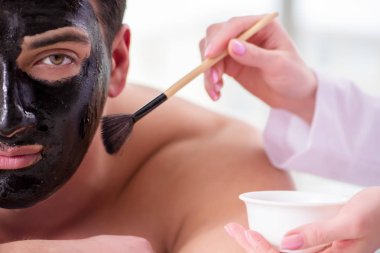 Kaplıca masaj konseptinde yakışıklı bir adam.